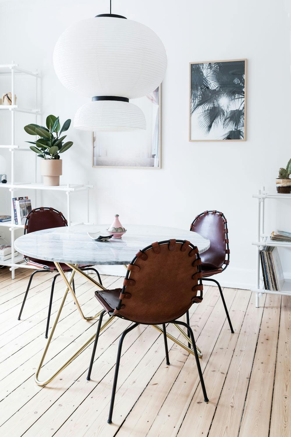 Lyst, klassisk og varmt Klassisk stil i spisestue med rundt marmorbord og stoler i brunt skinn
